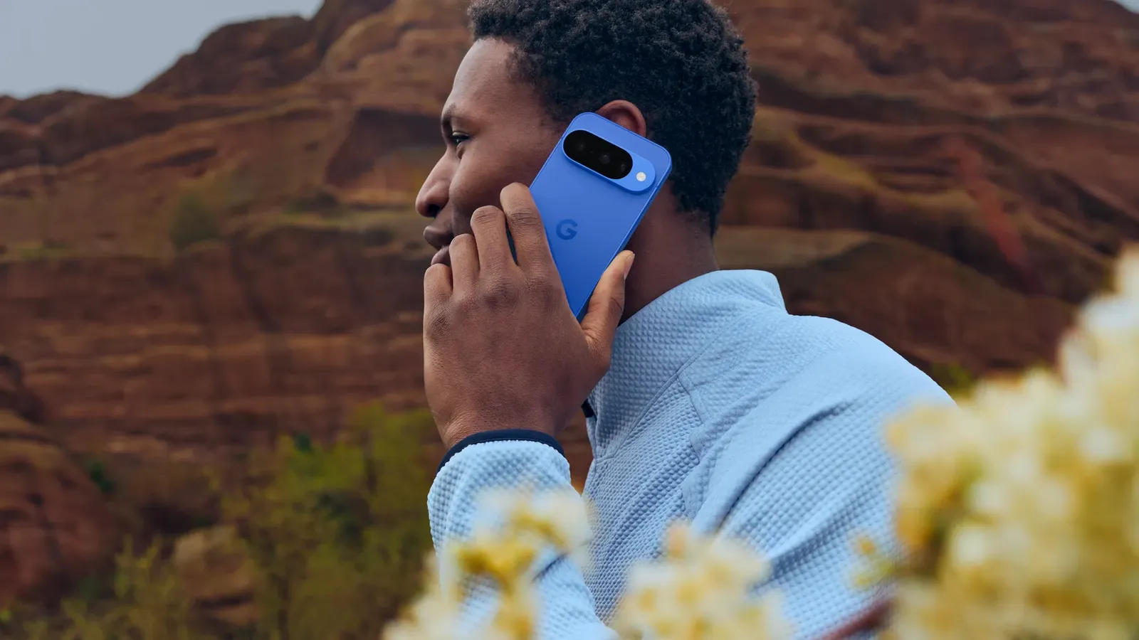 A man on a call holding a blue Pixel 10